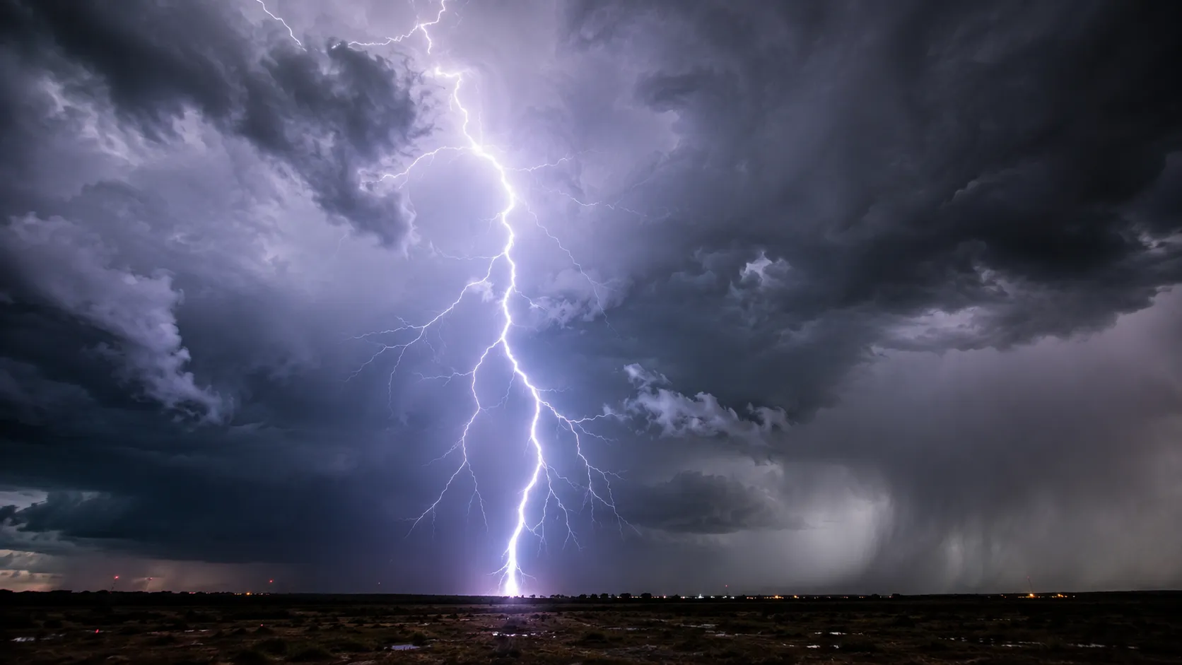 Lightning bolt striking during a nighttime storm with dark clouds overhead