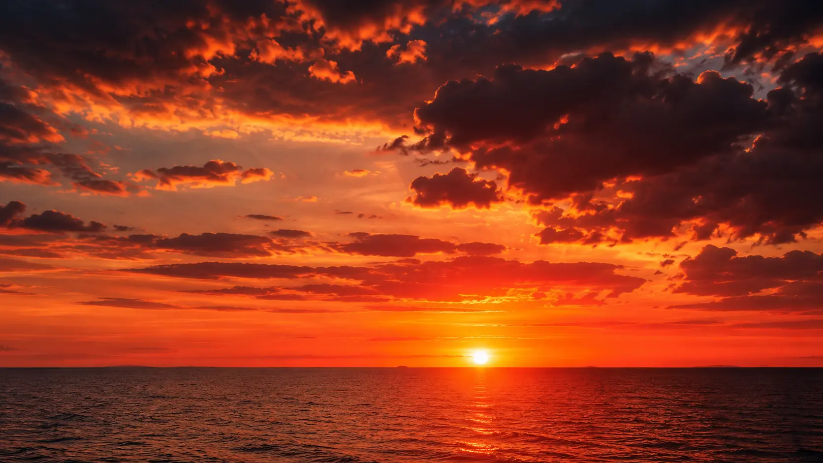Vivid red and orange sunset over a flat horizon