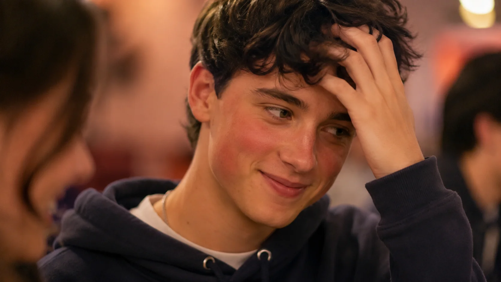 Person with visibly flushed red cheeks in a social setting